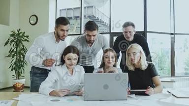 一群年轻的男人和女人正在忙着用笔记本电脑工作时间不等雇员正在<strong>做</strong>一项<strong>任务</strong>
